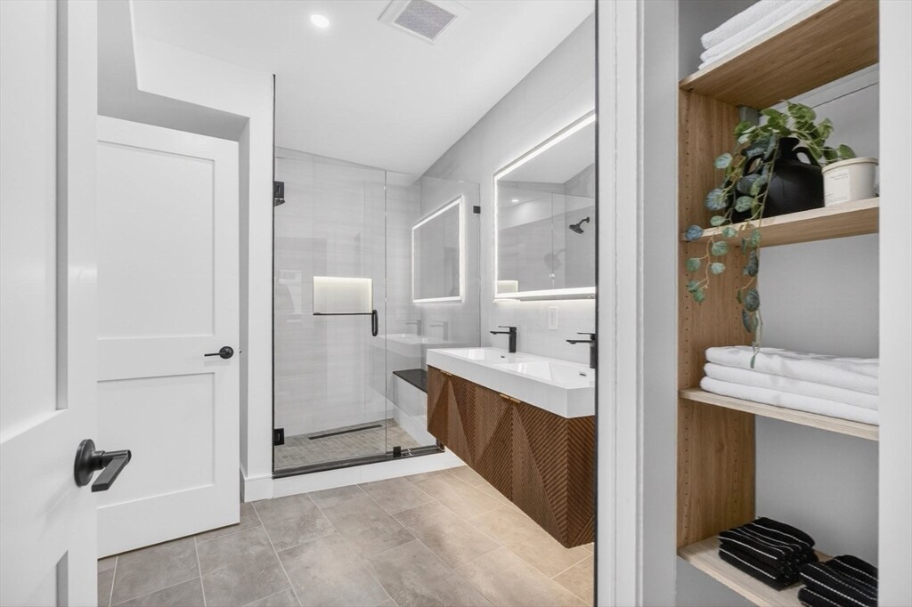 Full bath with a glass walk-in shower and floating vanity