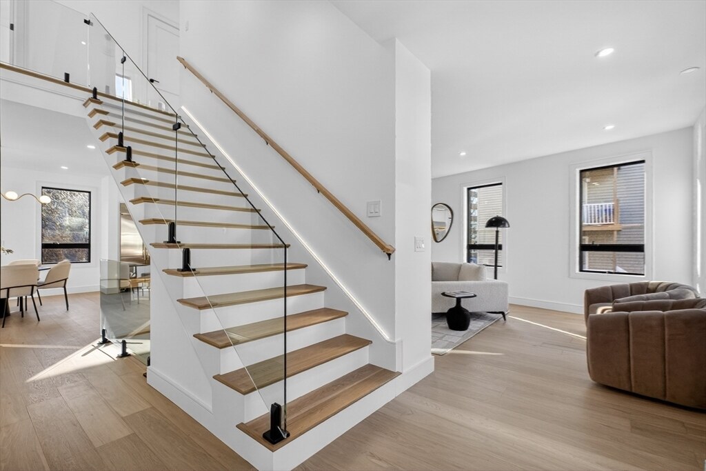 Sunlit entry with a sculptural open-riser staircase