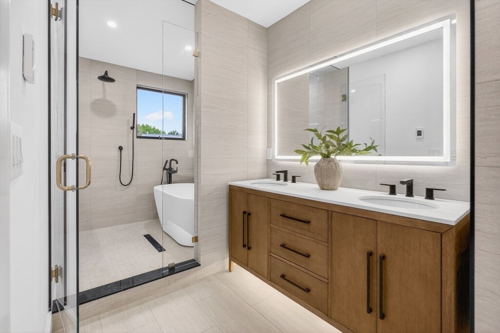 Spa-like primary bath with a soaking tub, glass shower, and double vanity
