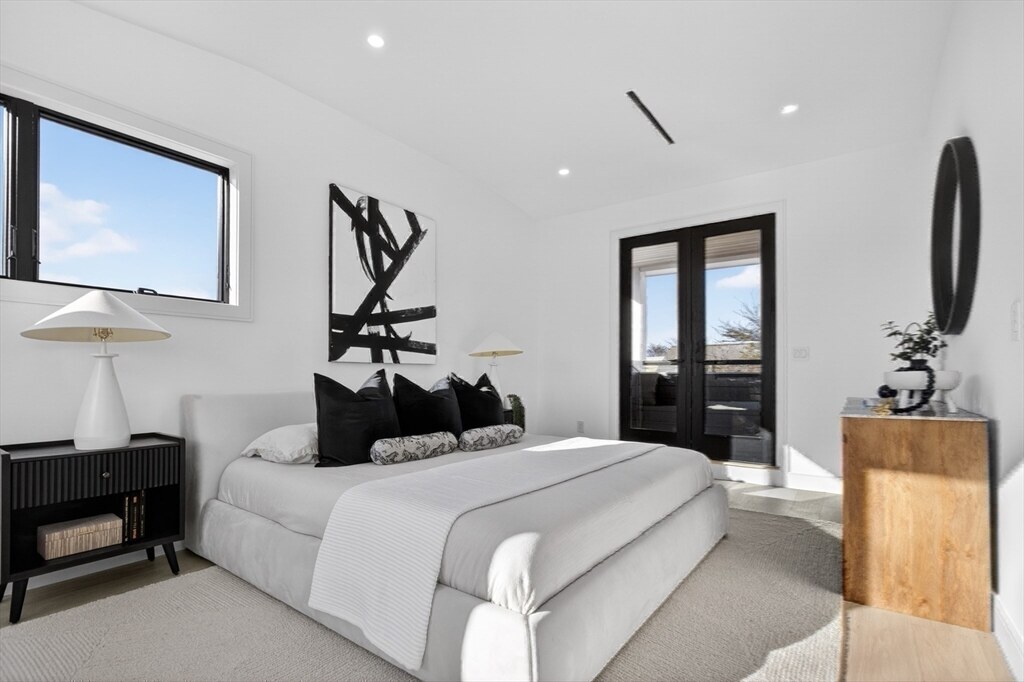 Primary bedroom with a vaulted ceiling and walkout to a private deck
