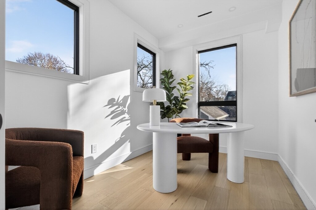 Sunlit sitting area with a round table and lounge chairs