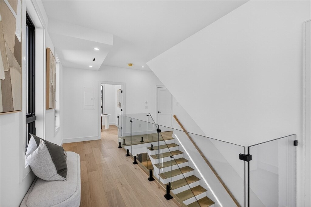 Upper landing with the open-riser staircase and glass railing